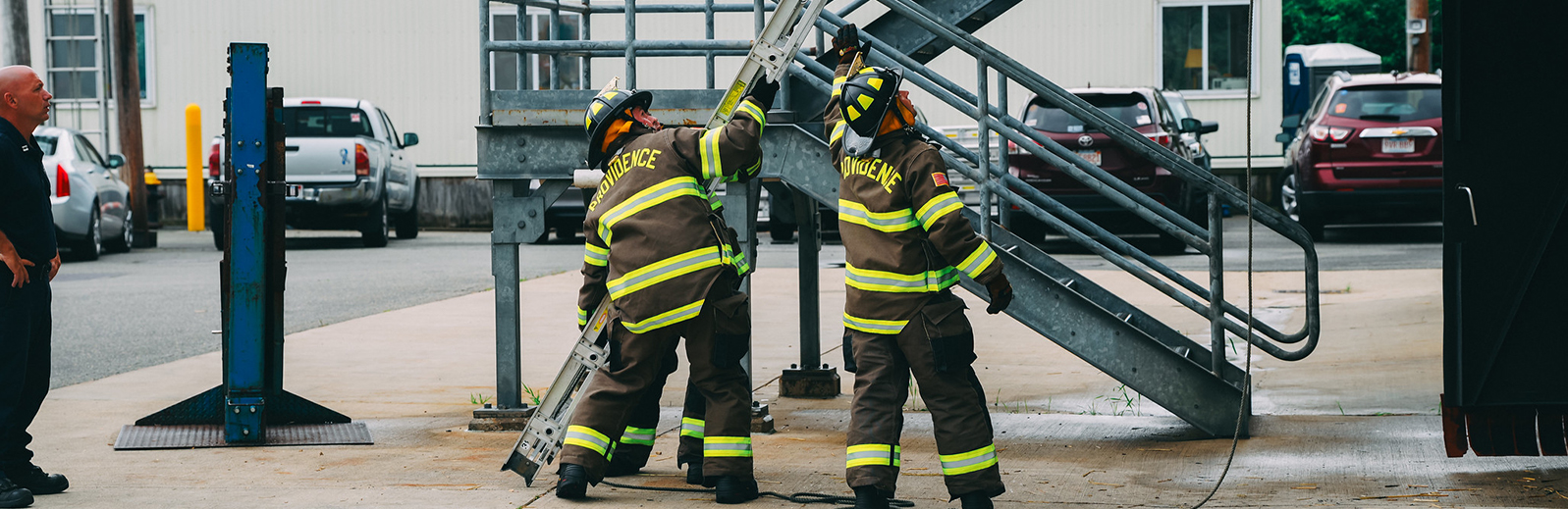 two firefighters holding up a ladder